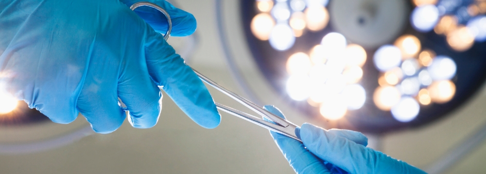 Two doctors exchanging surgical tool in the operating room